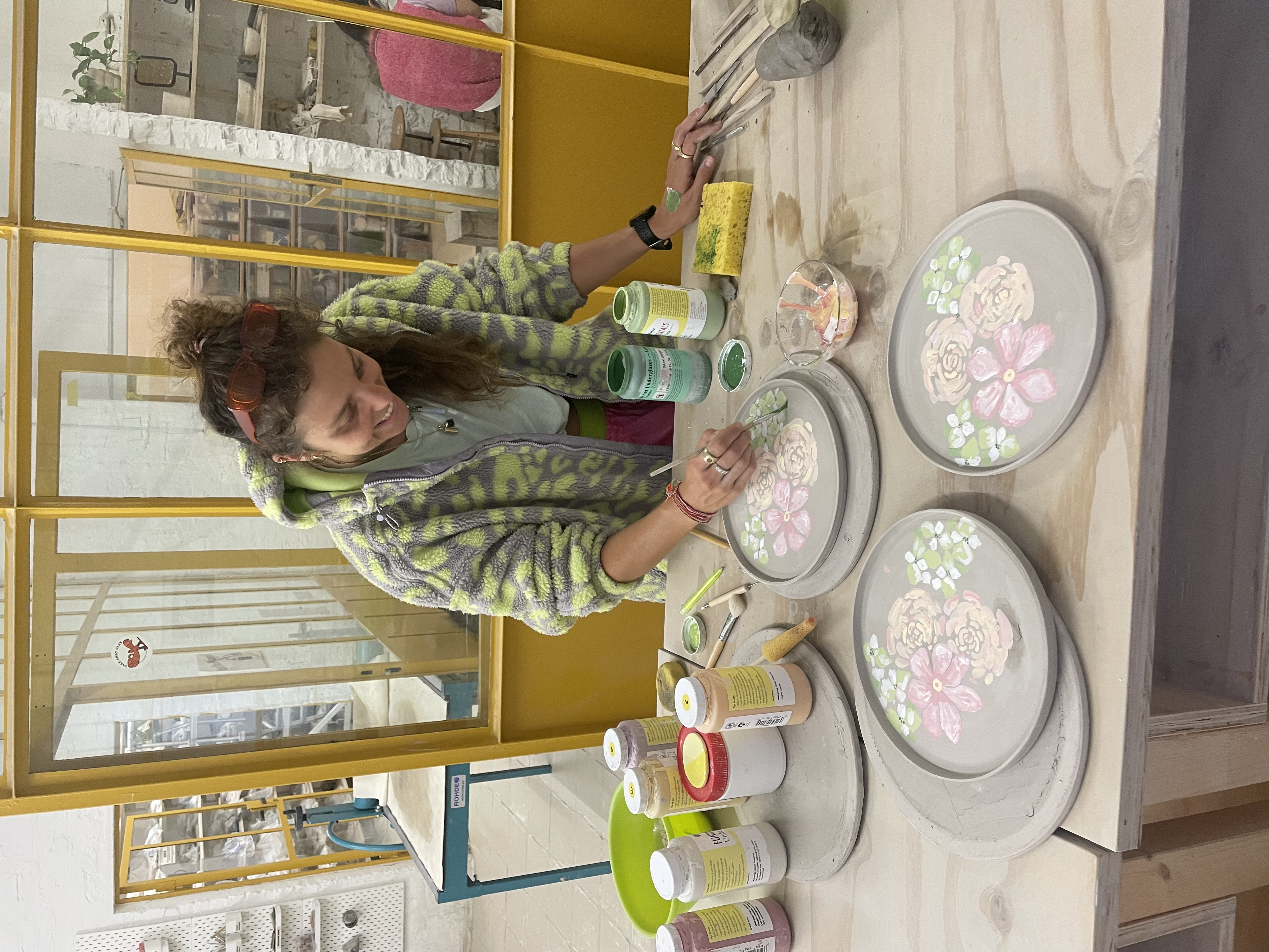 Isabel Kennedy arranging flowers in a studio doorway